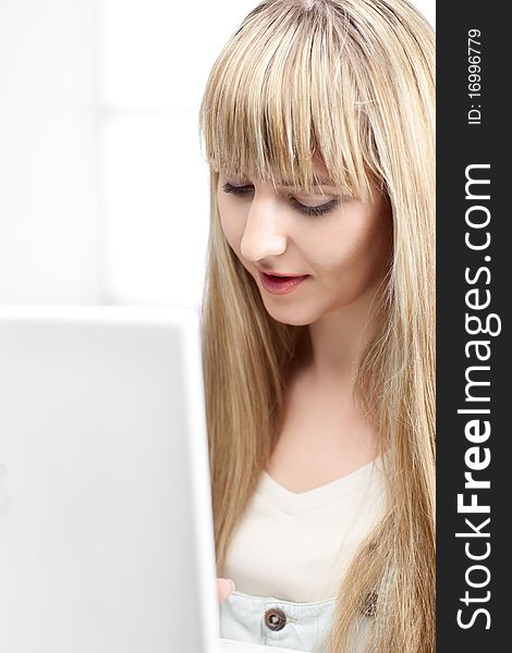 Woman in office with blond hair with laptop