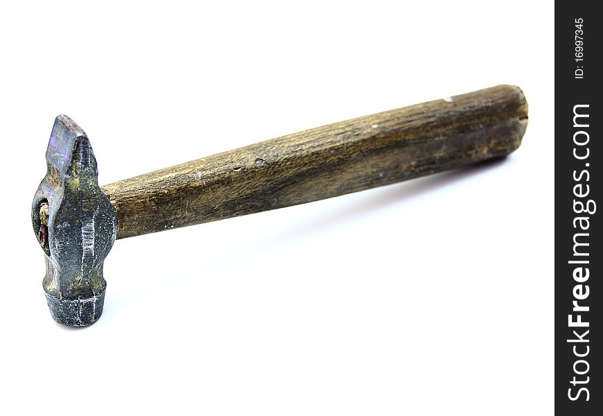 The old metal hammer with the wooden handle lies on a white background. The old metal hammer with the wooden handle lies on a white background