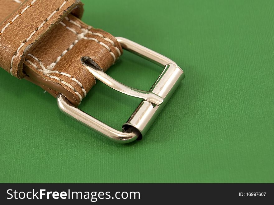 Leather belt buckle macro closeup green background