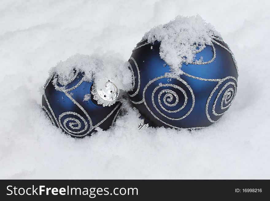 Two blue Christmas balls in snow