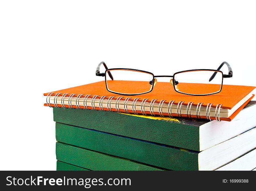 Orange notebook and eyeglasses isolated on white background