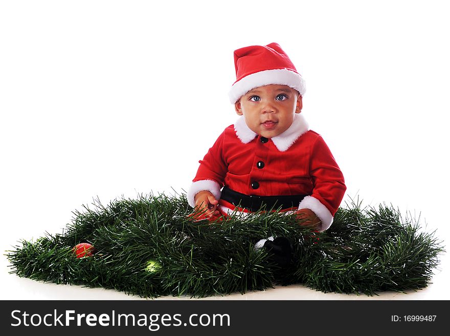 An adorable biracial baby dressed as Santa, sitting in the midst of Christmas garland. Isolated on white. An adorable biracial baby dressed as Santa, sitting in the midst of Christmas garland. Isolated on white.