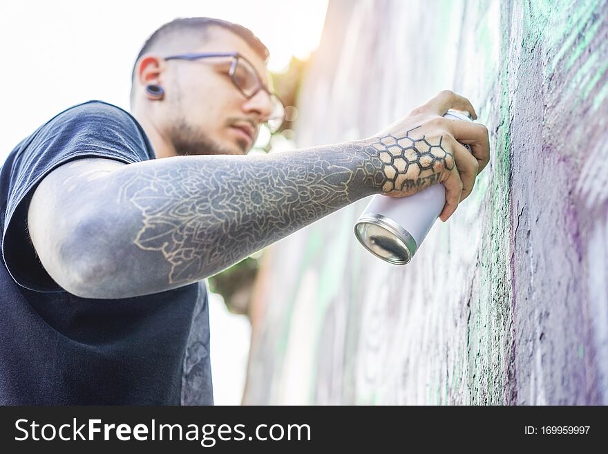 Tattooed Graffiti Artist Painting With Color Aerosol On The Wall - Contemporary Spray Write At Work - Urban Lifestyle,street Art
