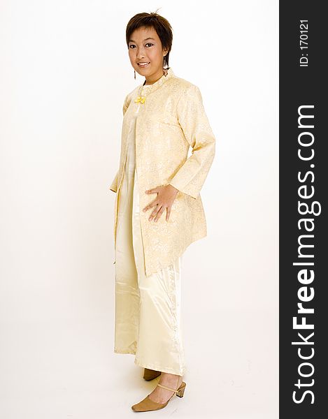 A full length shot of a young Malay woman wearing a traditional yellow jacket and dress. A full length shot of a young Malay woman wearing a traditional yellow jacket and dress