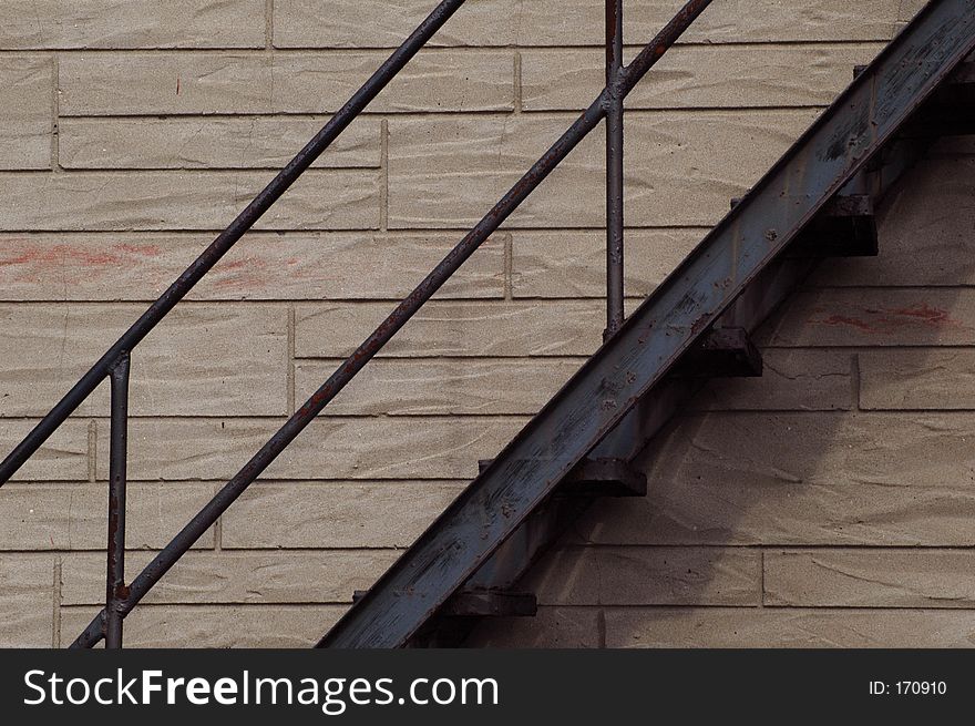 Rusty black fire escape against the brick wall of a residential building