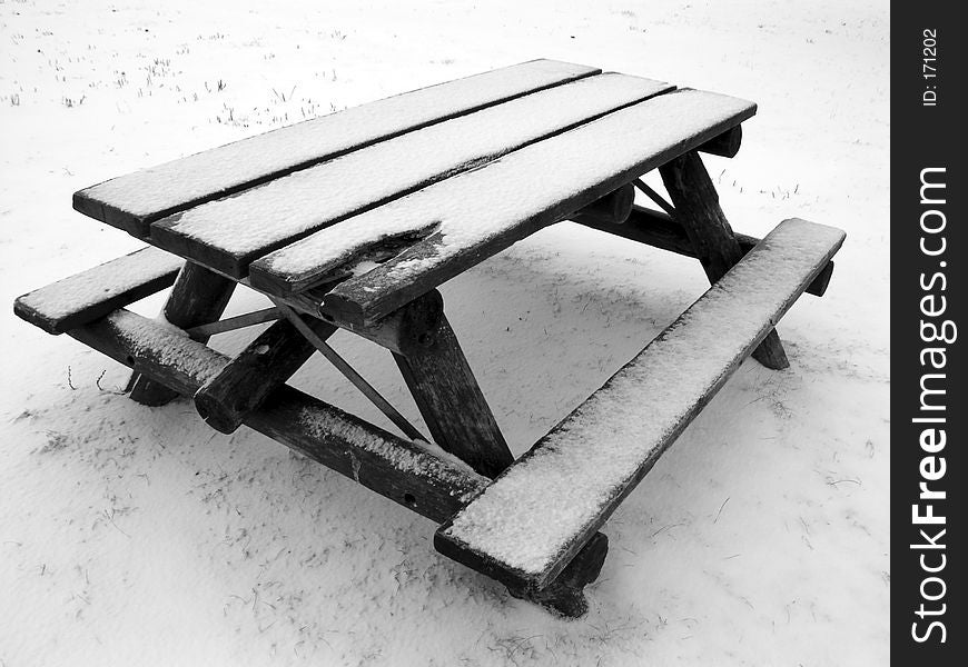 A snow-covered park bench. A snow-covered park bench..