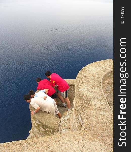 Curious teenager looking down from a high cliff