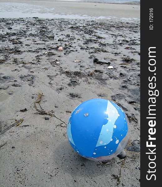 Plastic blue ball on sandy beach in maine. Plastic blue ball on sandy beach in maine