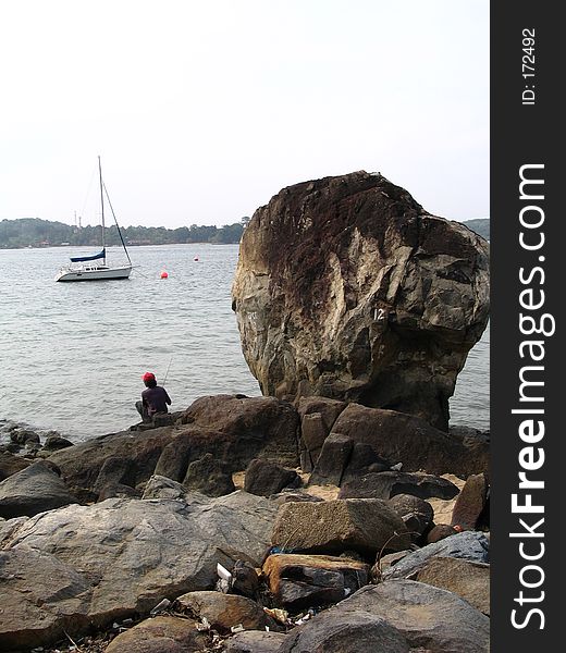 Fishing by Big Rock at Changi Beach, Singapore