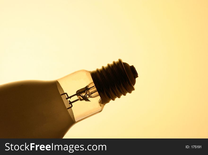 A large thread bulb silhouetted in front of a yellow background. A large thread bulb silhouetted in front of a yellow background
