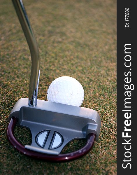 Putter and golfball on green being used. Putter and golfball on green being used