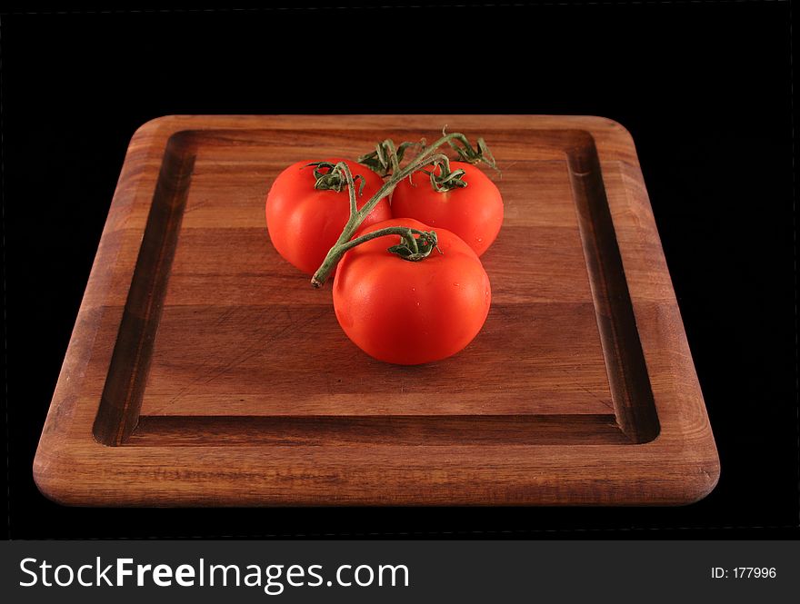 Three Tomatoes on wood cutting board. Three Tomatoes on wood cutting board