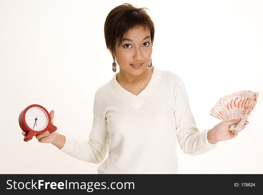A pretty young asian woman holds a clock and a lot of money. A pretty young asian woman holds a clock and a lot of money