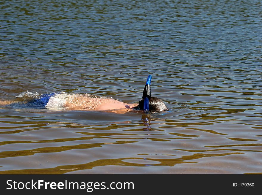 Young kid snorkeling in a lake