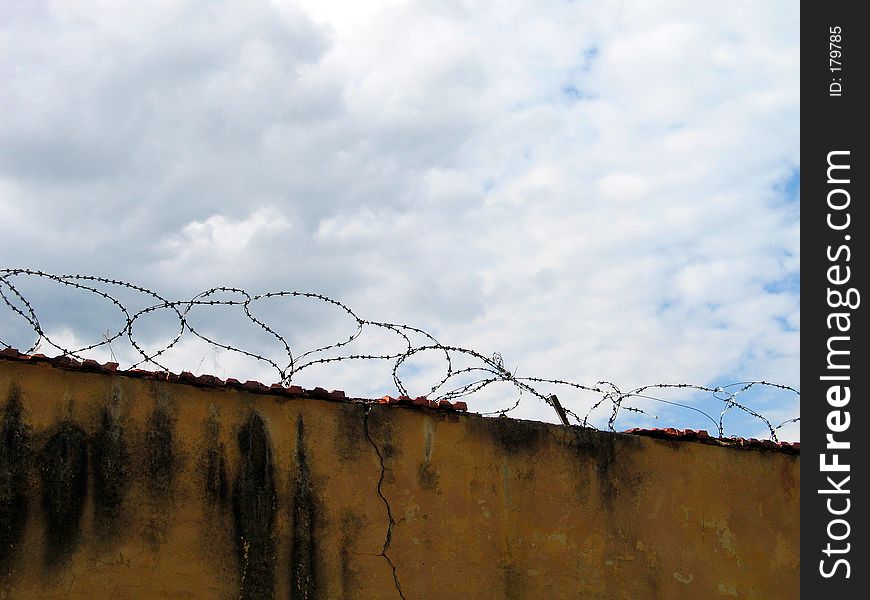 Barbed wire on top of a wall. Barbed wire on top of a wall