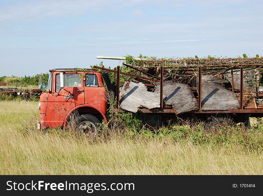 Old Red Truck in a Field in the Redlands Collecting Rust. Old Red Truck in a Field in the Redlands Collecting Rust