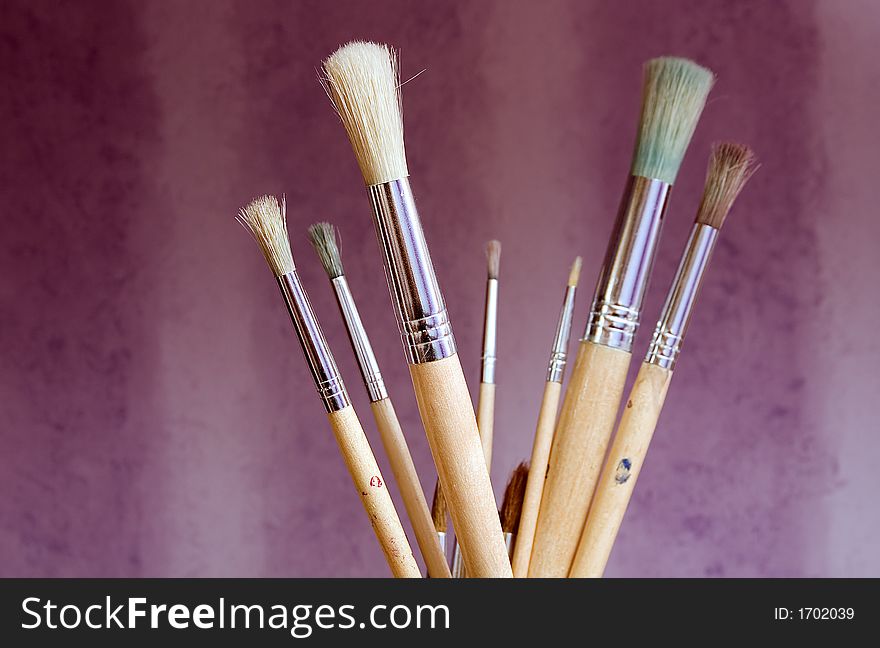 Various brushes against a purple background