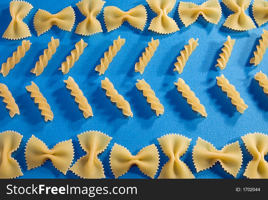 Various types of pasta on blue paper