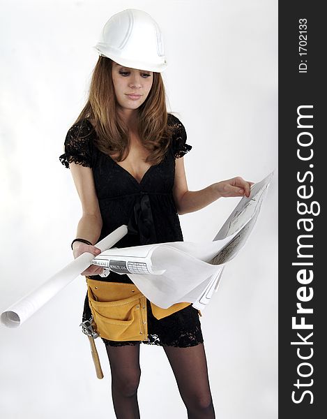 Young woman in a hardhat reading blueprints. Young woman in a hardhat reading blueprints