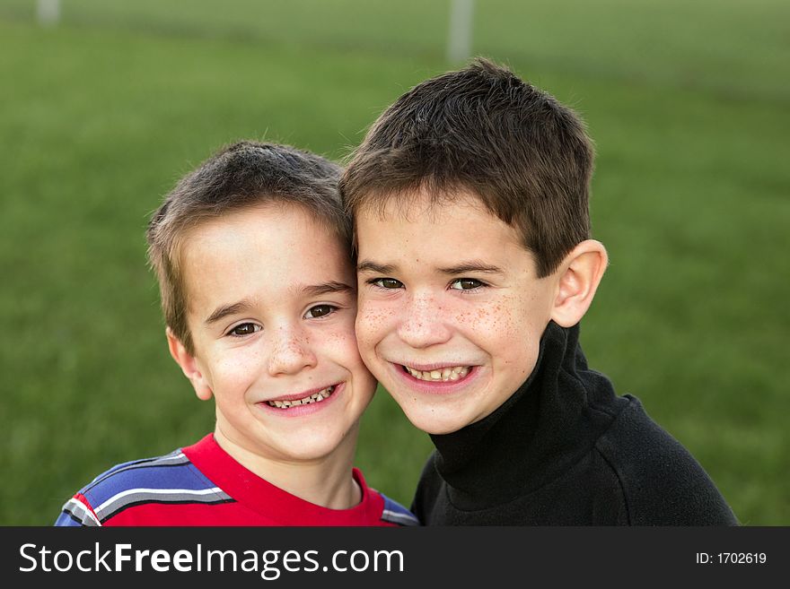 Brothers smiling with green grass background