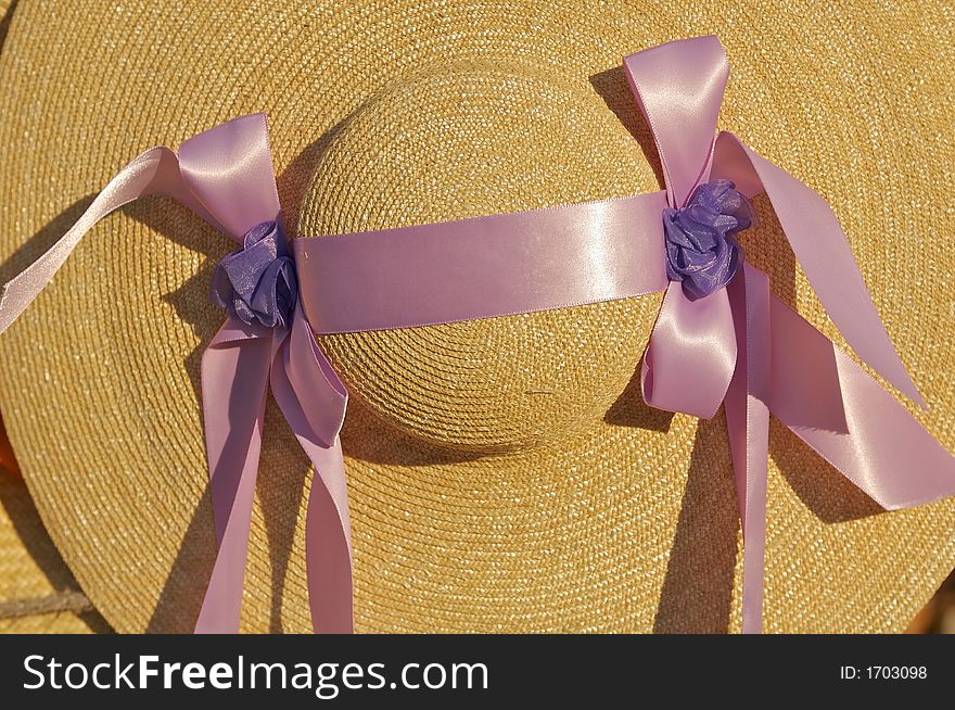 Straw bonnet with twin purple bows. Straw bonnet with twin purple bows