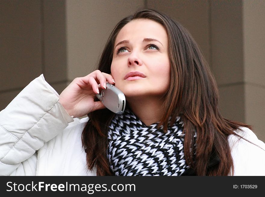 Portrait of a beutiful woman talking on the cell phone and looking far away smiling. Portrait of a beutiful woman talking on the cell phone and looking far away smiling