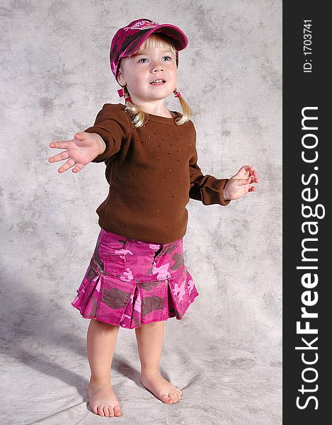 A cute little girl posing on a gray background. A cute little girl posing on a gray background.