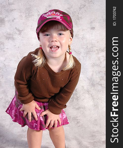 A cute little girl posing on a gray background. A cute little girl posing on a gray background.