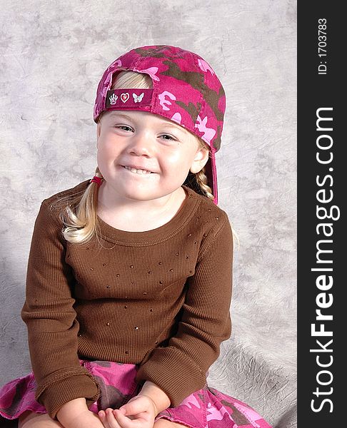 A cute little girl posing on a gray background. A cute little girl posing on a gray background.