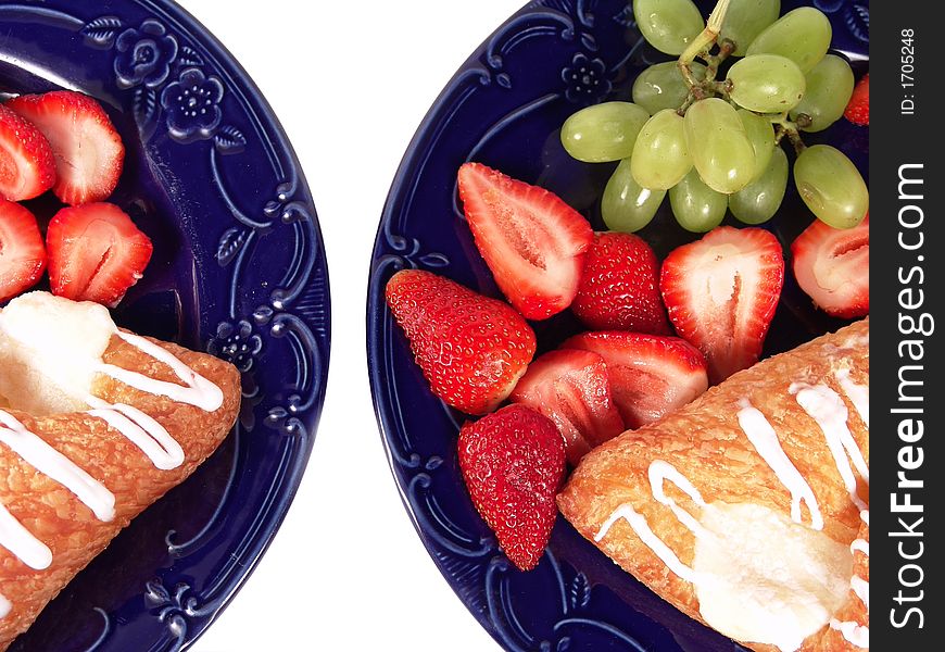 Pastry, grapes and strawberry on two blue plates