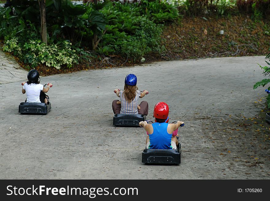 children playing slide cart on a slope