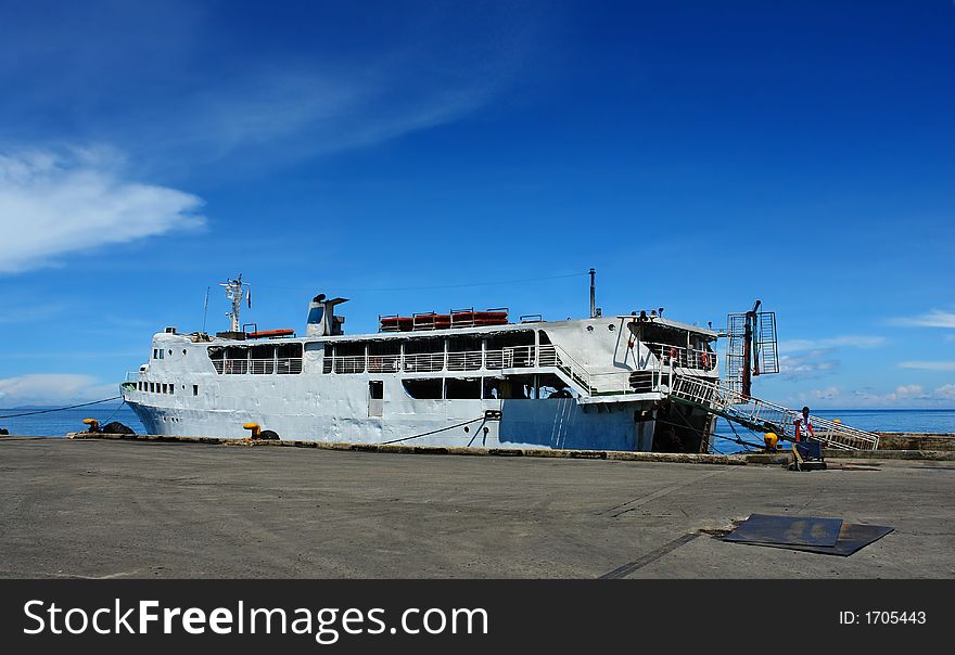 Old rusty ferry boat docked in a tropical Southeast Asian port. Old rusty ferry boat docked in a tropical Southeast Asian port.