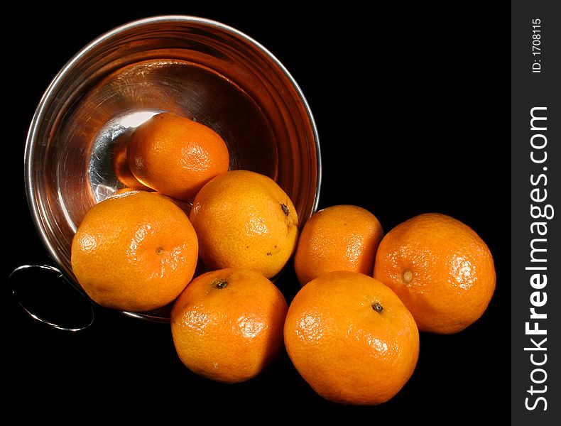 Clementines imported from Spain in a basket on a black background. These are also knows as Satsumas and are grown in southern Louisiana.