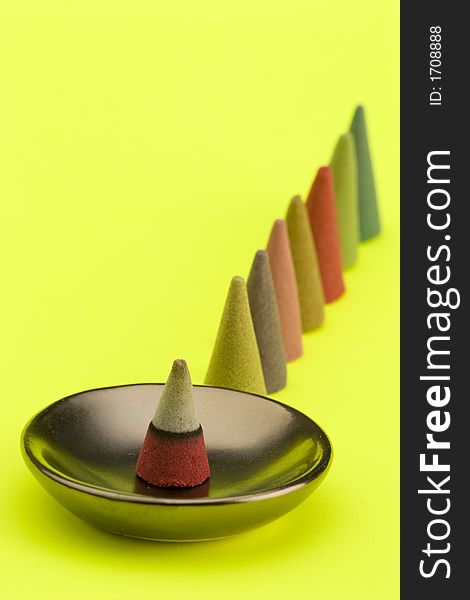 Multi coloured Incense cones against a bright coloured background.