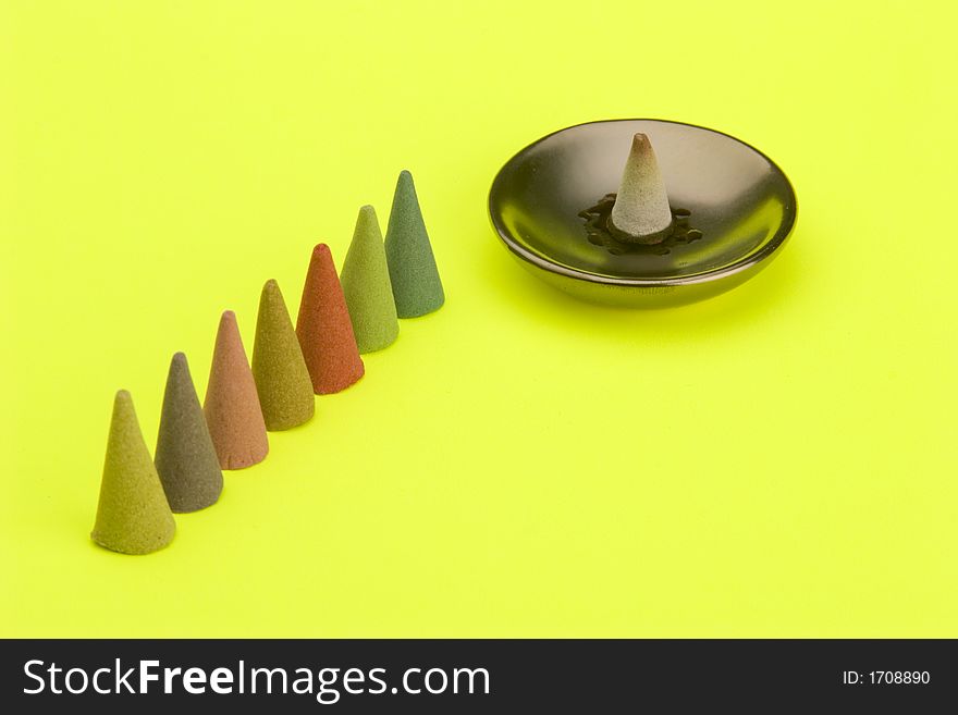 Multi coloured Incense cones against a bright coloured background.