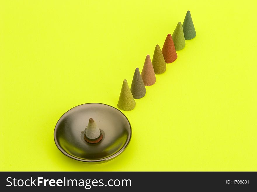 Multi coloured Incense cones against a bright coloured background.