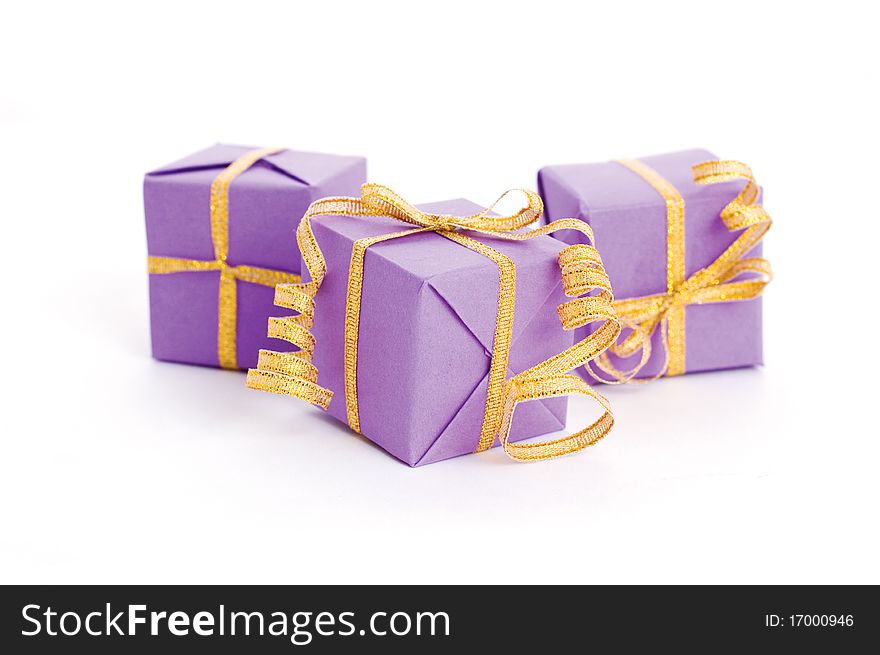Lilac boxes with golden ribbon isolated on white background. Lilac boxes with golden ribbon isolated on white background