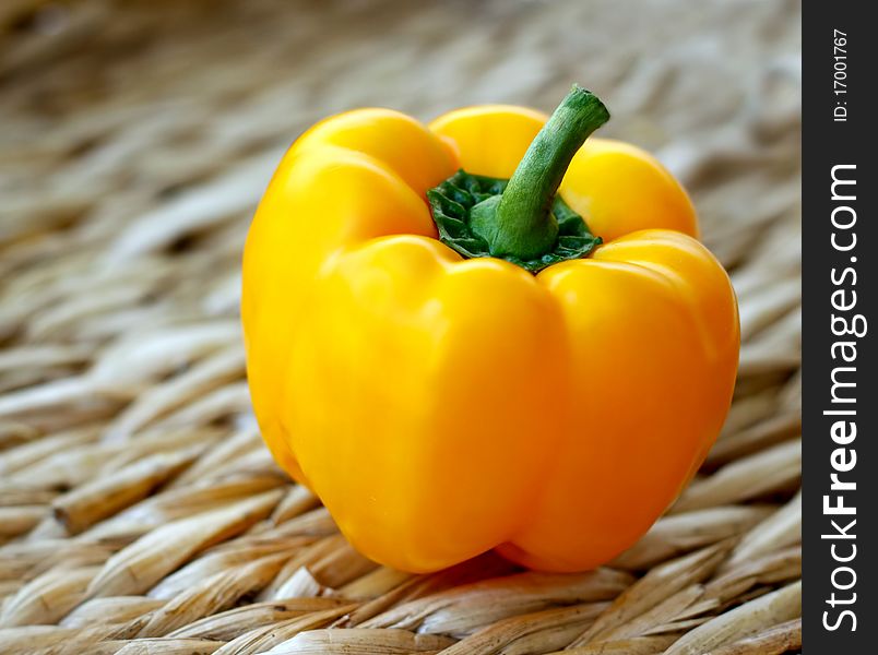 Yellow bell pepper on a table-mat.