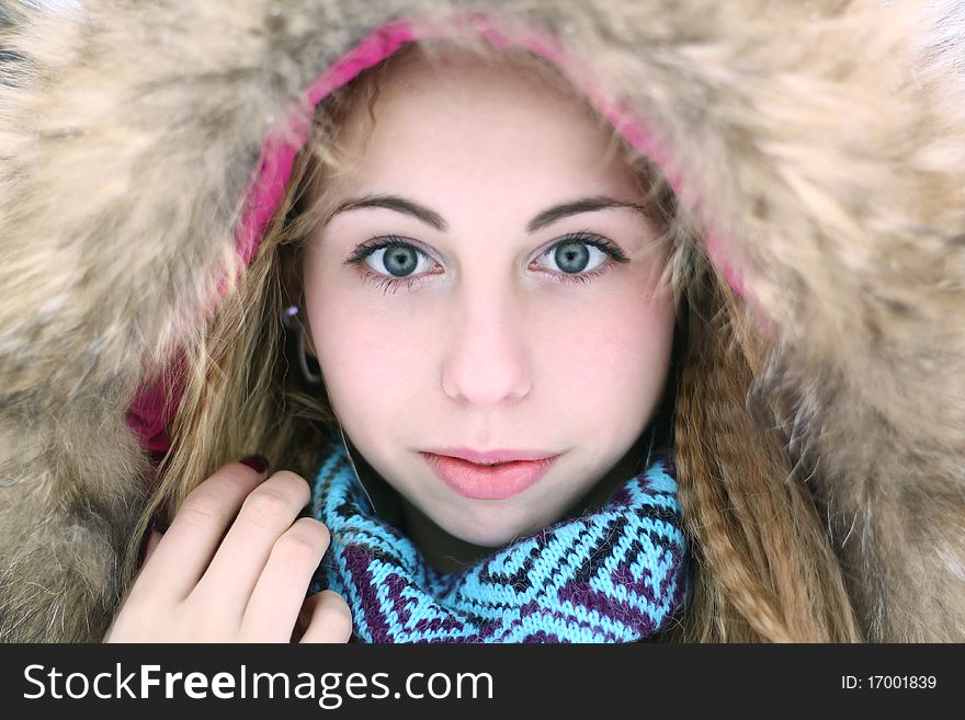 A teenage girl wearing a wintercoat with a furry hood. A teenage girl wearing a wintercoat with a furry hood