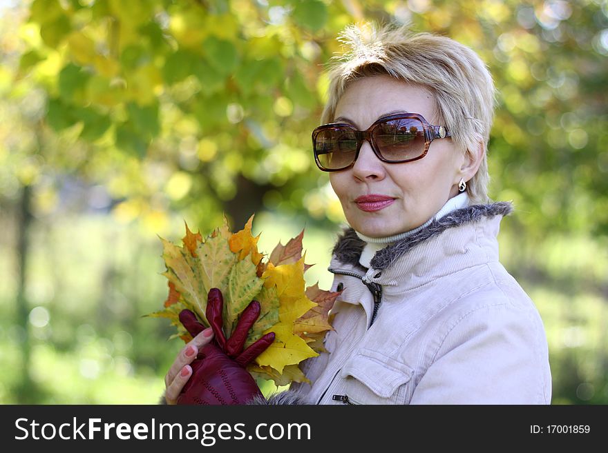 WhiteWoman in the sunglasses in the autumn park