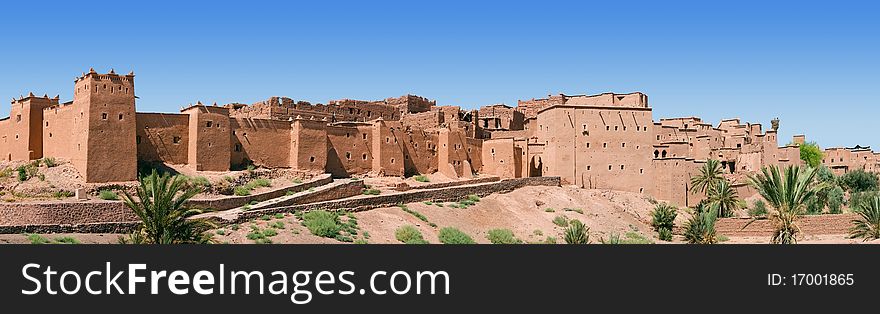 A panorama of a Moroccan kasbah with some trees on a summers day. A panorama of a Moroccan kasbah with some trees on a summers day.