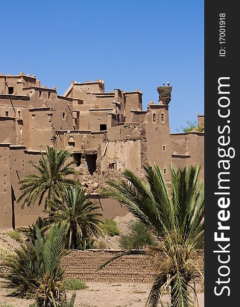 A view of a Moroccan kasbah with some palm trees. A view of a Moroccan kasbah with some palm trees.