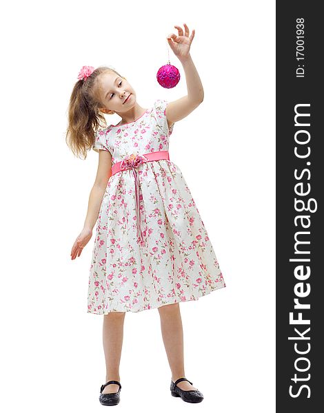 Cute little girl in dress playing with a christmas-tree decoration on white background isolated