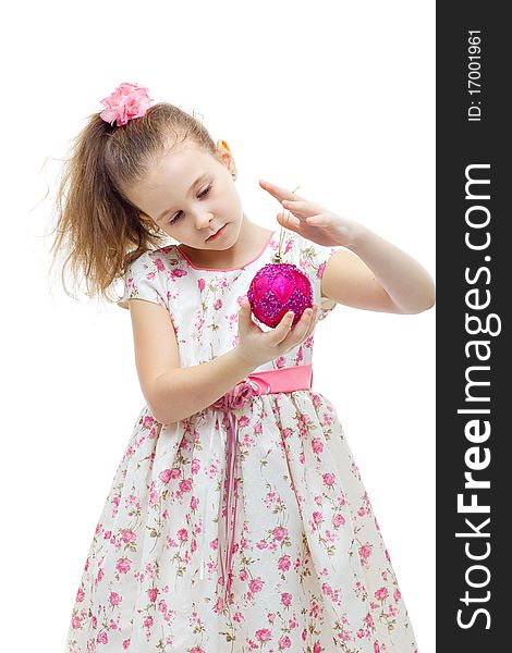 Cute little girl in dress playing with a christmas-tree decoration on white background isolated