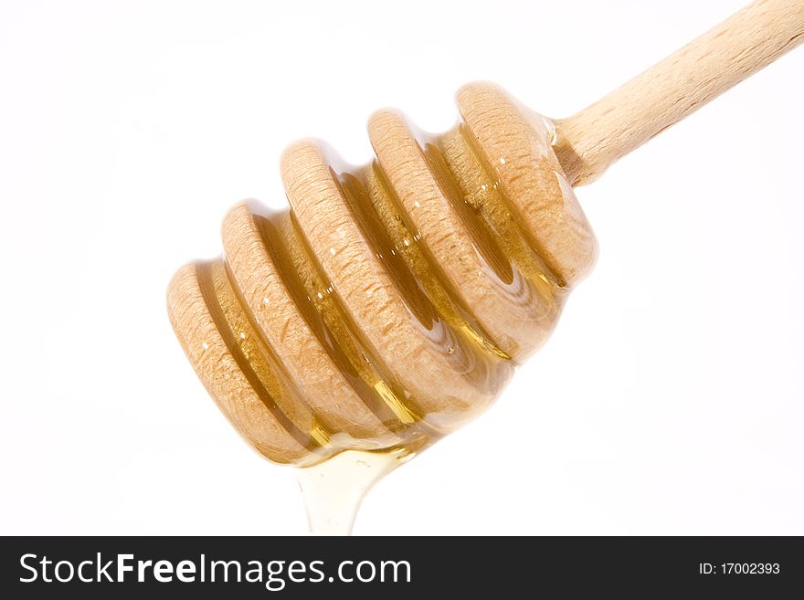 Wooden honey drizzle with a stream of honey