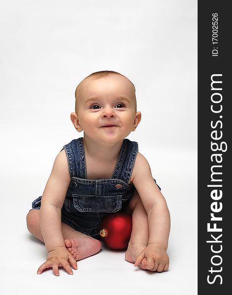 Baby playing with the Christmas glass ball on the white background. Baby playing with the Christmas glass ball on the white background