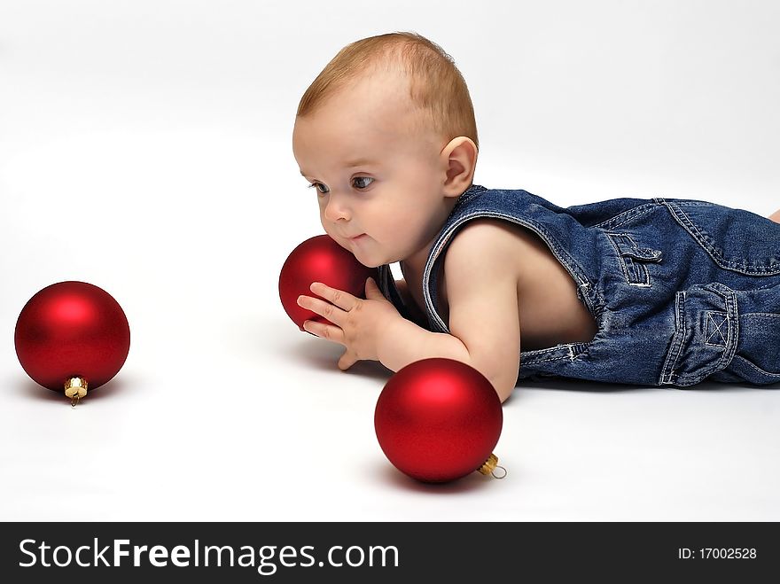 Baby playing with the Christmas glass ball on the white background. Baby playing with the Christmas glass ball on the white background