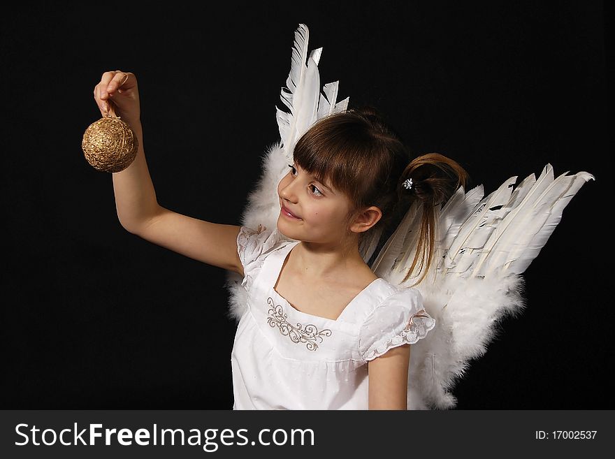 Girl playing with the Christmas glass ball on the black background. Girl playing with the Christmas glass ball on the black background