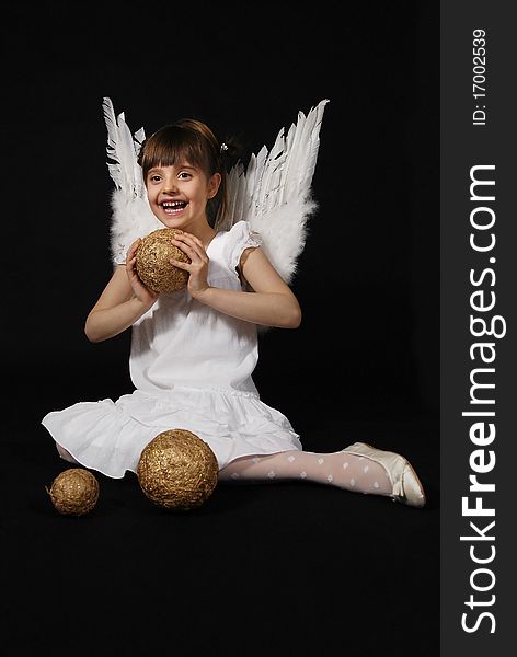 Girl playing with the Christmas glass ball on the black background. Girl playing with the Christmas glass ball on the black background