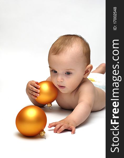 Baby playing with the Christmas glass ball on the white background. Baby playing with the Christmas glass ball on the white background